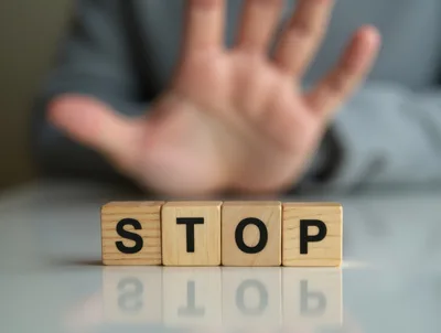 Hand Gesturing Stop Behind Wooden Blocks Spelling Stop