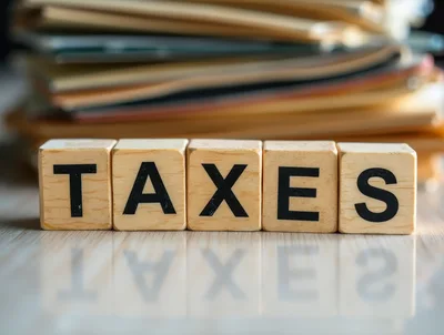 Wooden Blocks Spelling Taxes With Blurred File Folders