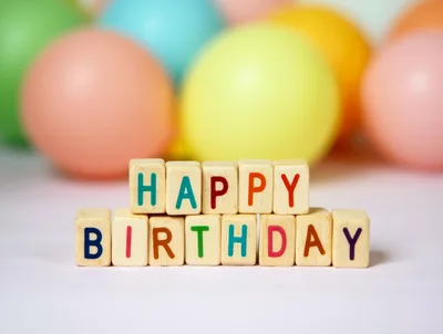 Wooden Blocks Spelling Happy Birthday With Colorful Balloons
