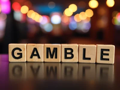 Wooden Blocks Spelling Gamble On Reflective Surface