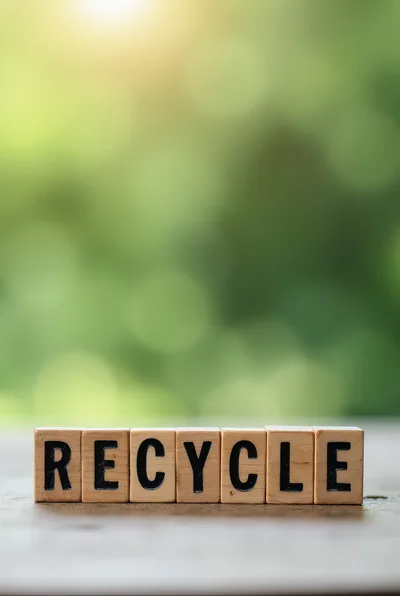 Wooden Blocks Spelling Recycle On A Blurred Green Background