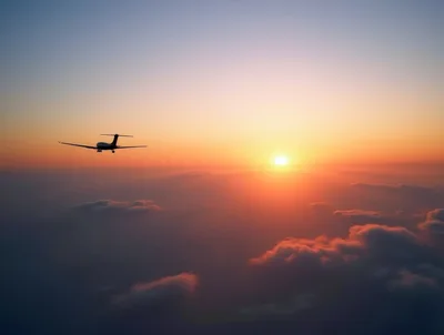 Airplane Flying Above Clouds During Sunset