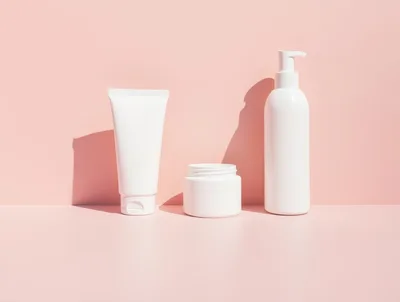 Three White Cosmetic Containers On Pink Background