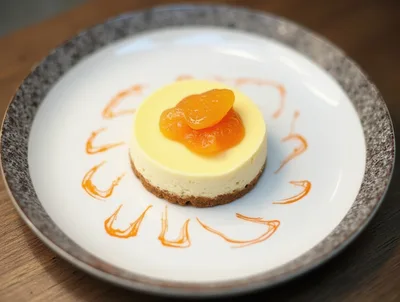 Small Round Cheesecake With Apricot Topping On Plate