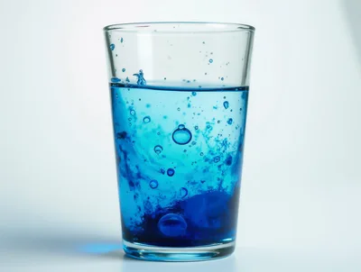 Blue Effervescent Tablet Dissolving In A Glass Of Water