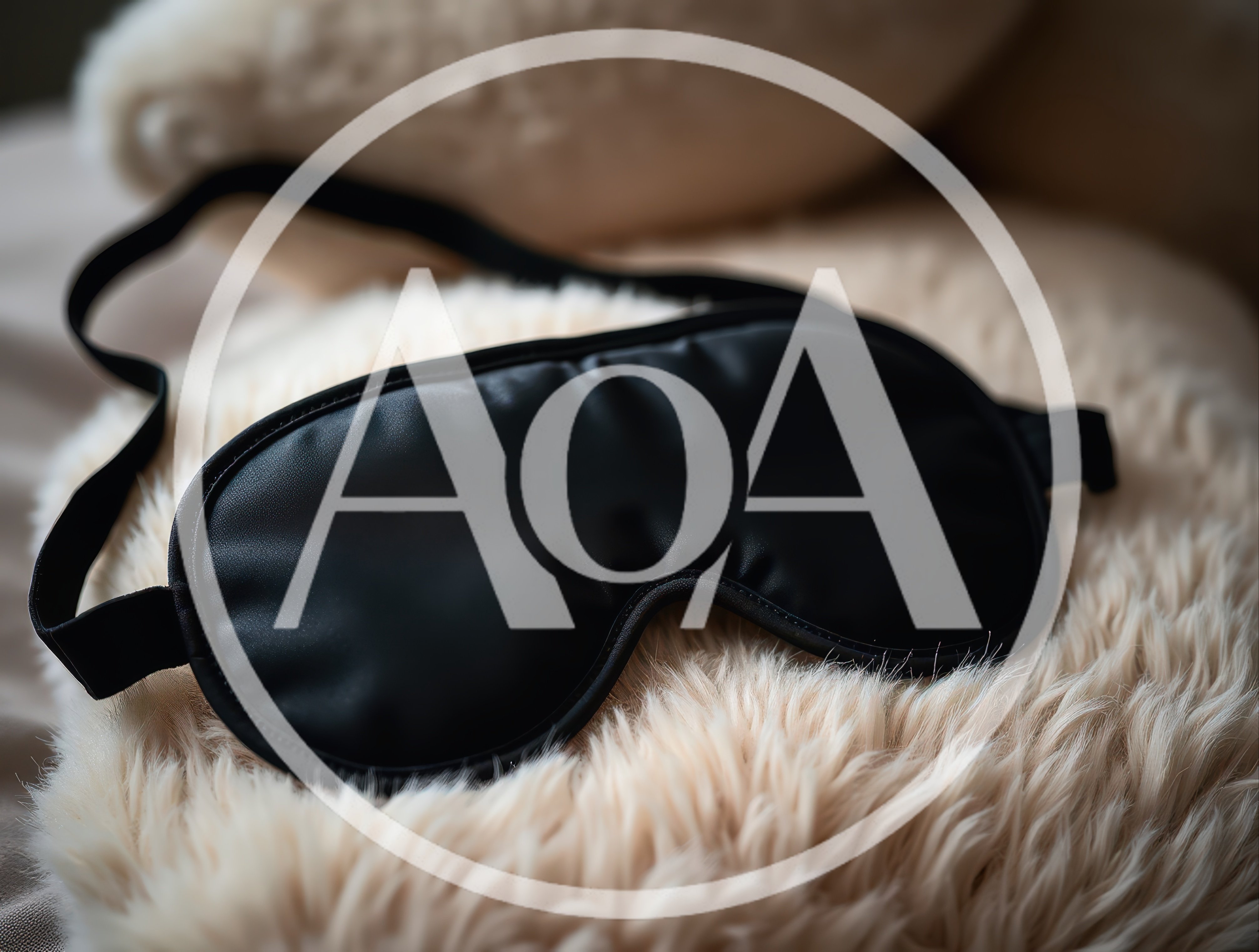 Black Silk Sleep Mask Resting On Fluffy Pillow