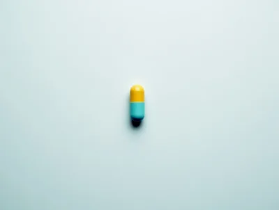 Single Yellow And Blue Capsule Pill On White Background