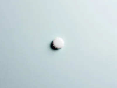 Single White Pill On A Light Blue Background