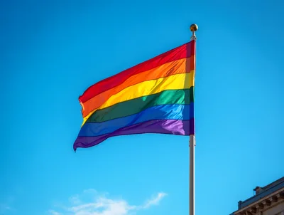 Rainbow Pride Flag Waving Against Clear Blue Sky