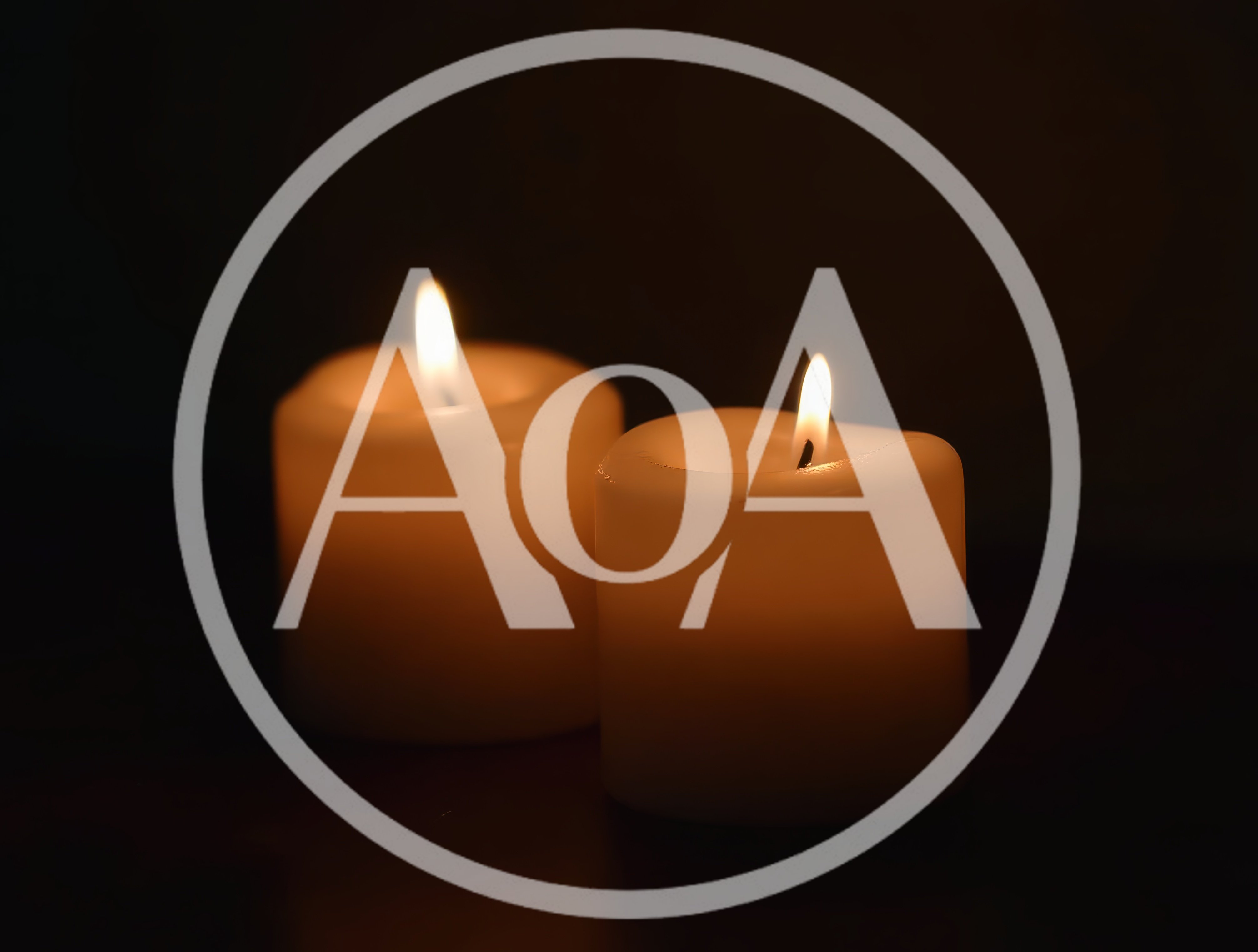 Two Lit Pillar Candles Glowing In The Dark