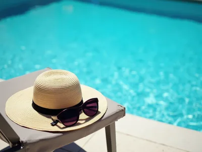 Straw Hat and Sunglasses on Poolside Lounge Chair