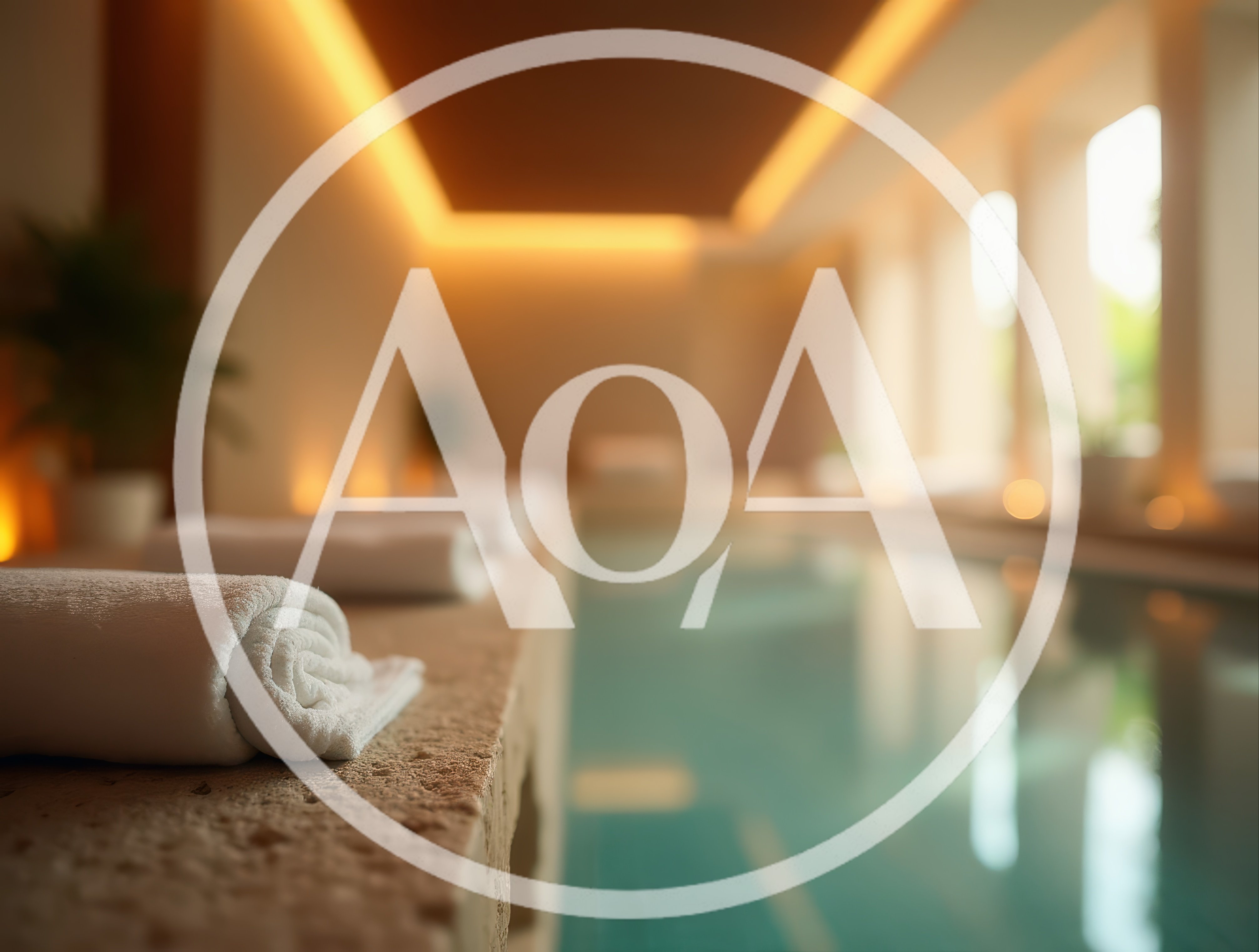Rolled White Towels Beside A Luxury Indoor Swimming Pool
