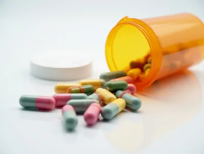 Prescription Medication Capsules Spilled From An Orange Bottle