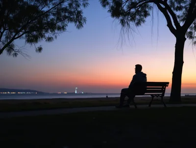Silhouette Of A Man Sitting On A Park Bench