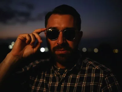 Man Adjusting Sunglasses During Twilight Outdoors