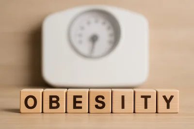 Wooden Blocks Spelling Obesity In Front Of Weighing Scale