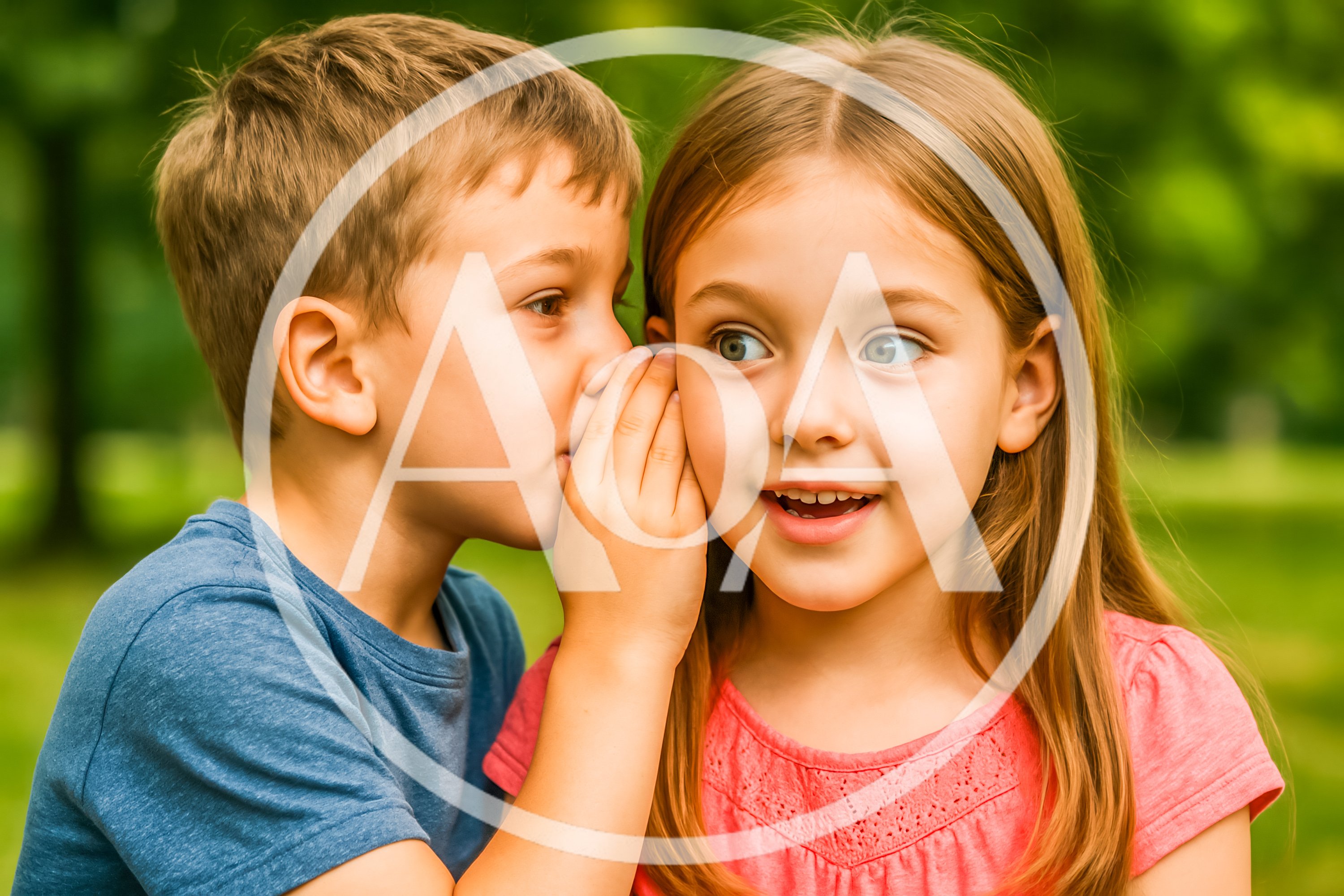 Young Boy Whispering A Secret To A Girl