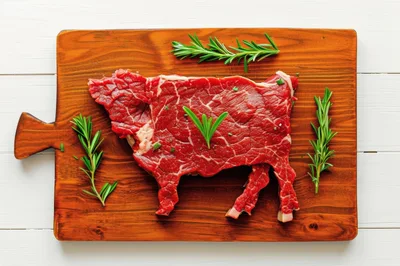 Raw Beef Steak Shaped Like A Cow On Cutting Board