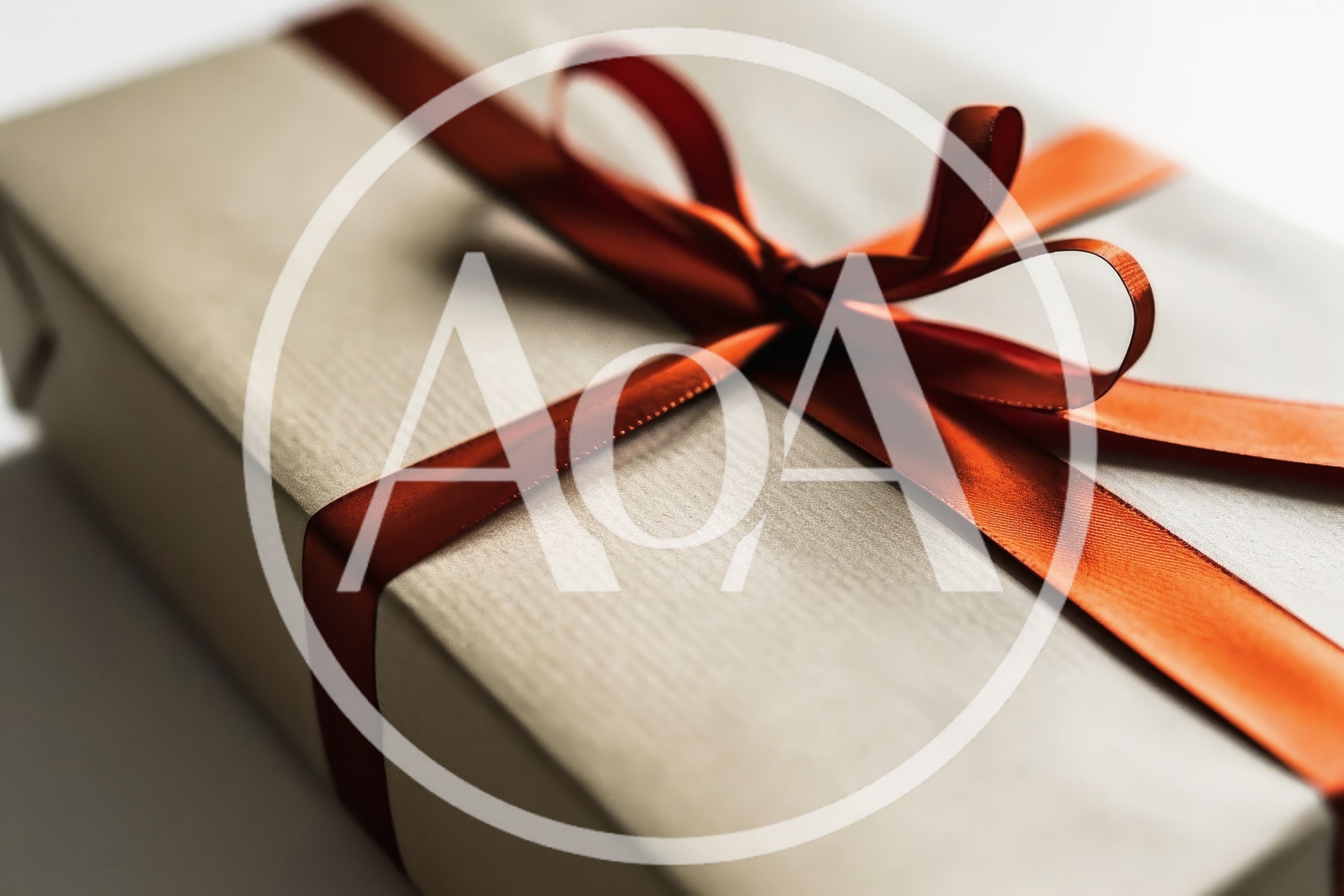 Gift Box Wrapped In Beige Paper With Red Ribbon