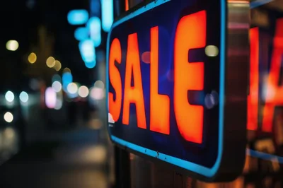 Neon Sale Sign Glowing In A City Street At Night