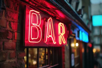 Glowing Red Neon Bar Sign On Brick Wall