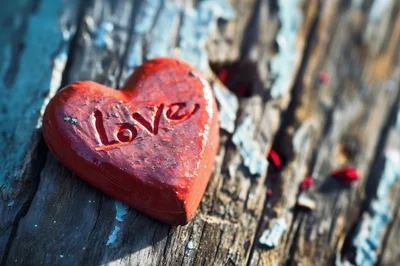 Red Heart Ornament With Love Inscription On Weathered Wood