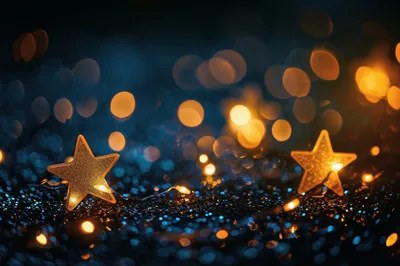 Two Golden Star Ornaments on Glittering Blue Background