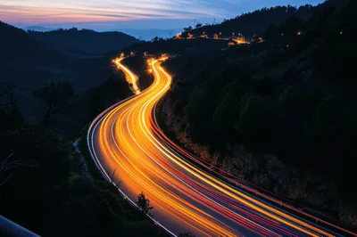 Long Exposure Light Trails On Winding Mountain Road