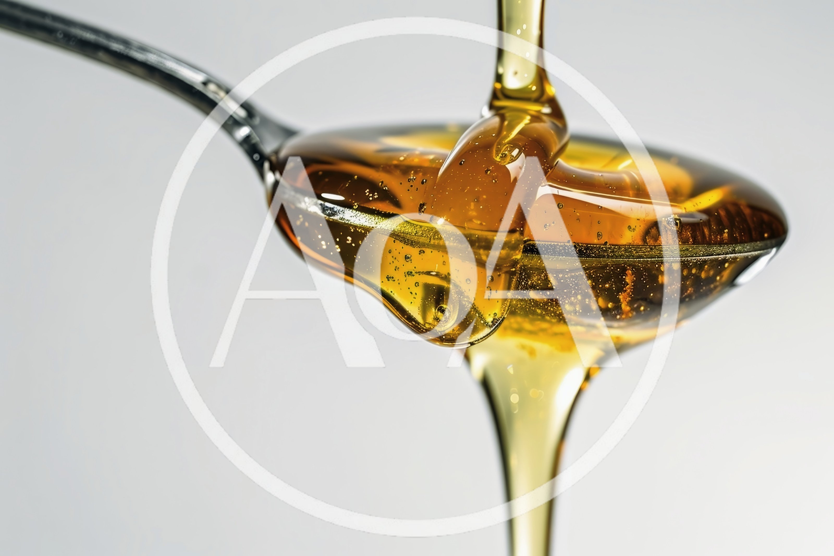 Golden Honey Pouring Over A Metal Spoon