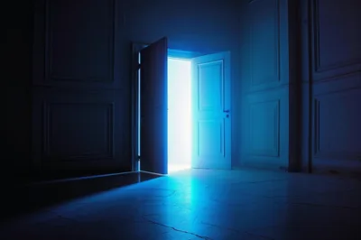 Open Doorway With Bright Blue Light In Dark Room