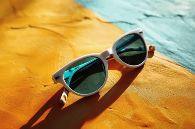 White Sunglasses Resting On A Textured Two Tone Surface