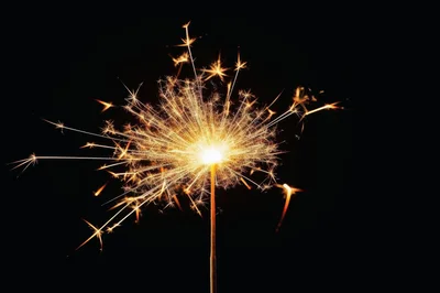 Bright Burning Sparkler Against A Dark Background