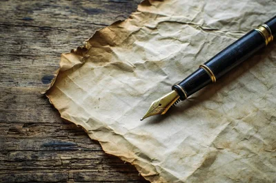 Fountain Pen Resting On Aged Parchment Paper