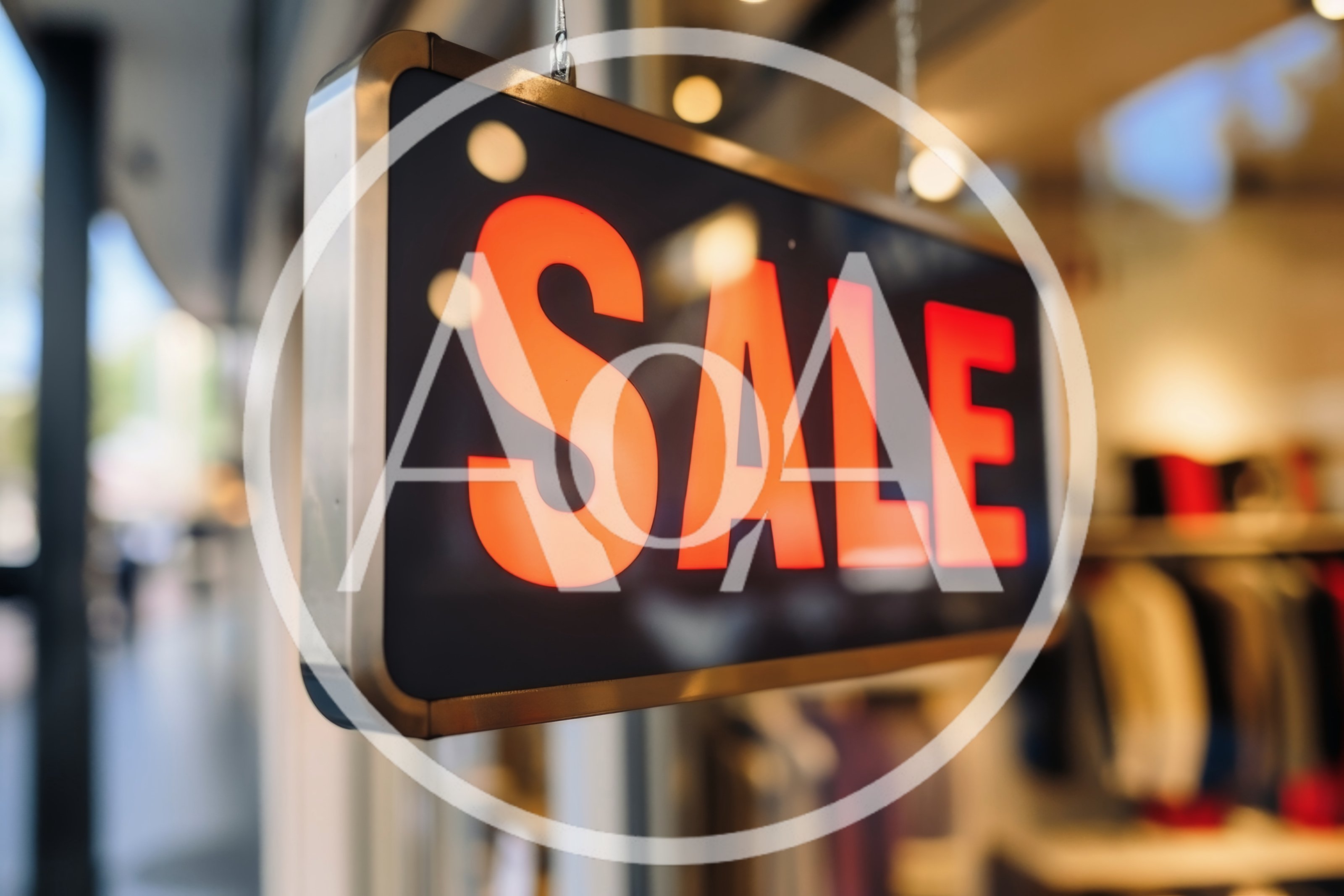 Illuminated Sale Sign Hanging In A Store Window