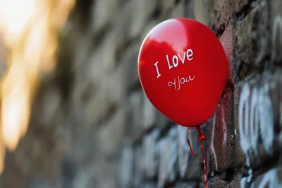 Red Balloon With I Love You Text Against Brick Wall