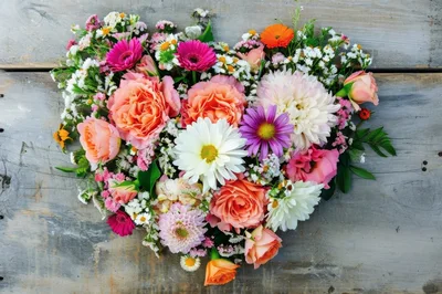 Heart Shaped Bouquet Of Colorful Flowers On Rustic Wood