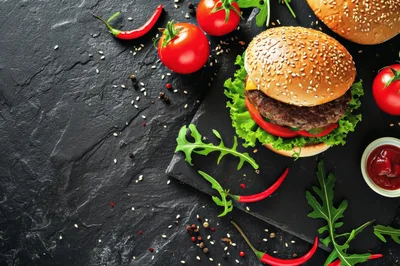 Gourmet Cheeseburger With Fresh Vegetables On Slate Board
