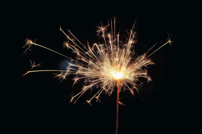 Bright Burning Sparkler Against A Dark Background