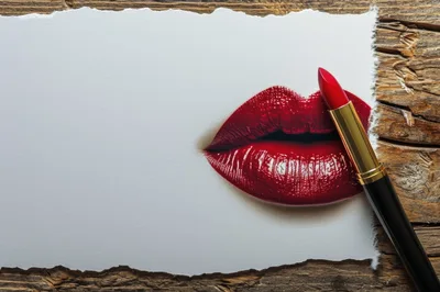 Red Lipstick Applied on Paper Over Wooden Background