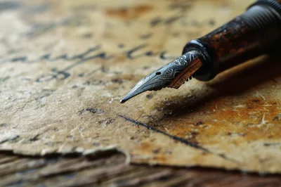 Vintage Fountain Pen Resting On Aged Parchment Paper