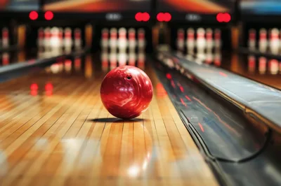 Red Bowling Ball Rolling Down Wooden Lane