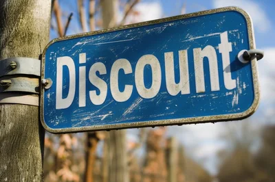 Blue Metal Discount Sign Attached To A Wooden Post