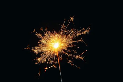 Bright Burning Sparkler Against Black Background