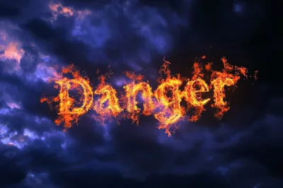 Fiery Danger Text Burning Against A Dark Stormy Sky