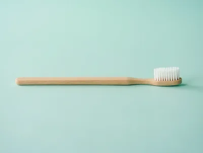 Wooden Toothbrush On A Pastel Green Background