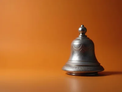 Silver Bell Isolated On A Solid Orange Background