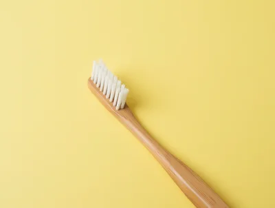 Eco Friendly Bamboo Toothbrush on Yellow Background