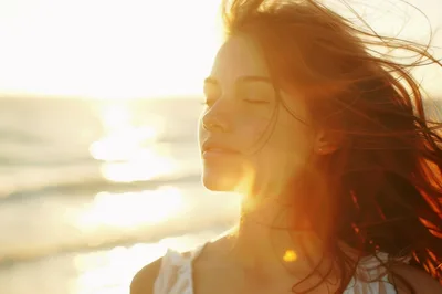 Young Woman Enjoying Sunset Breeze at the Beach