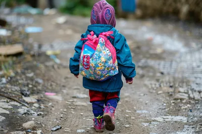 Young Child Walking Alone on a Dirt Path