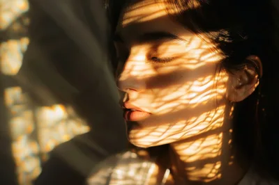 Close Up Portrait Of A Woman With Sunlight Patterns